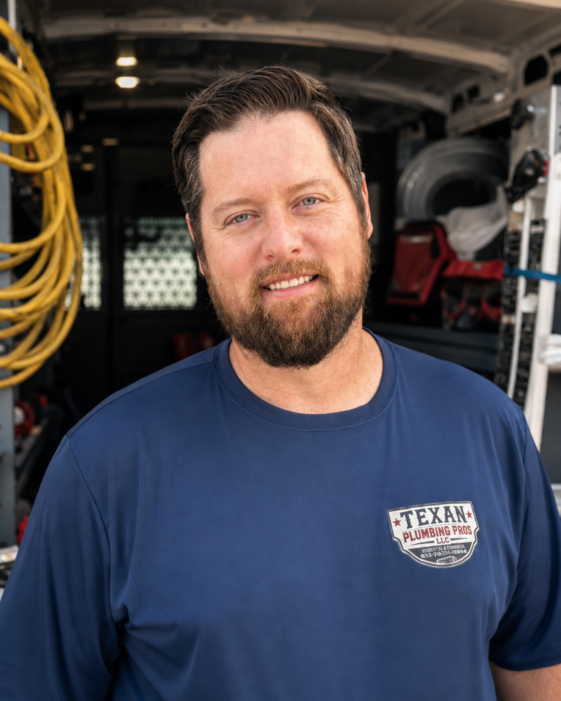 Andy Fauver of Texan Plumbing Pros in a company shirt in front of the service van